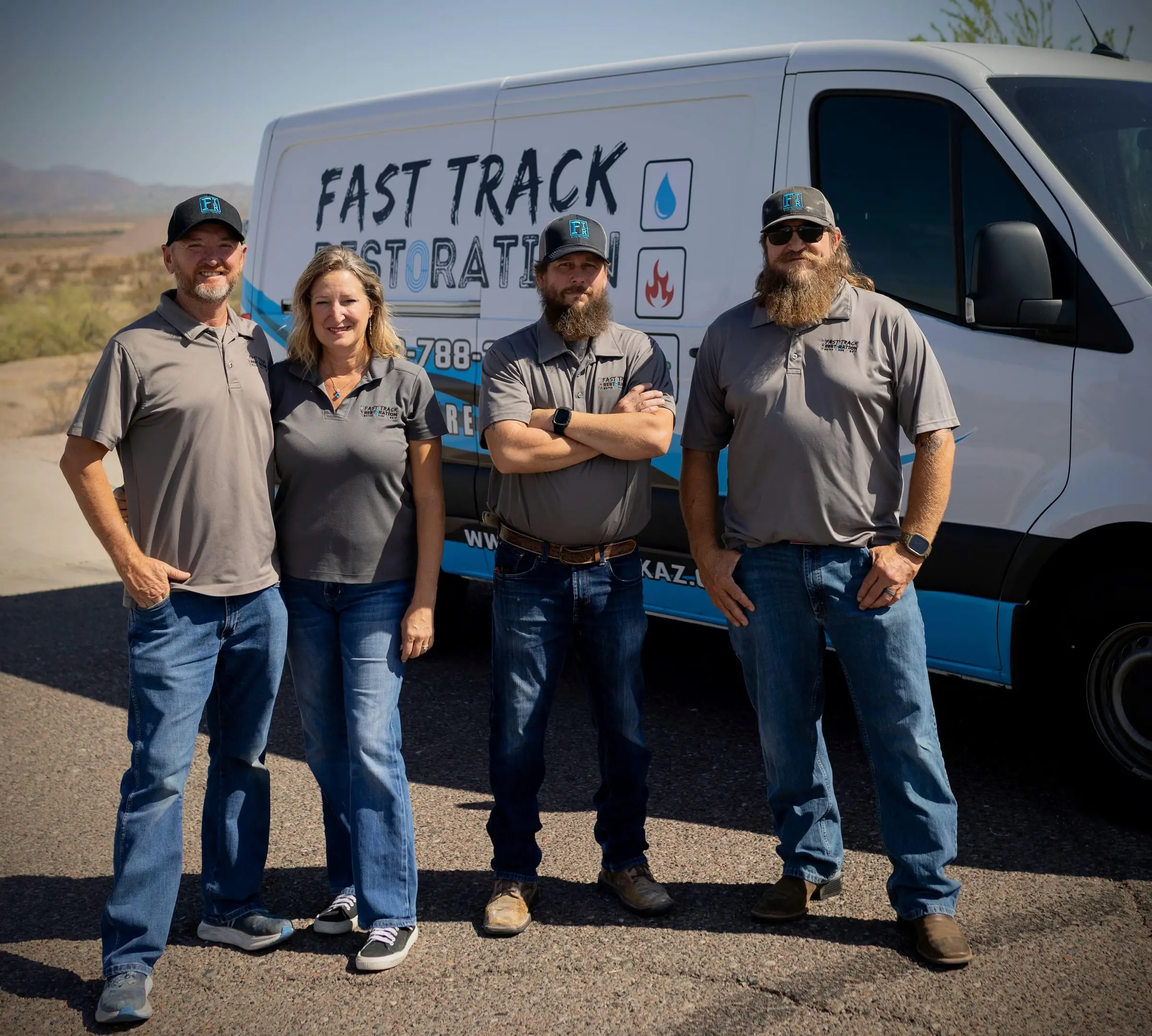 Fast Track Restoration's senior team — Becci Stoflet, Brian Bradford, Chad Hale, and Logan Bone — in front of a company van