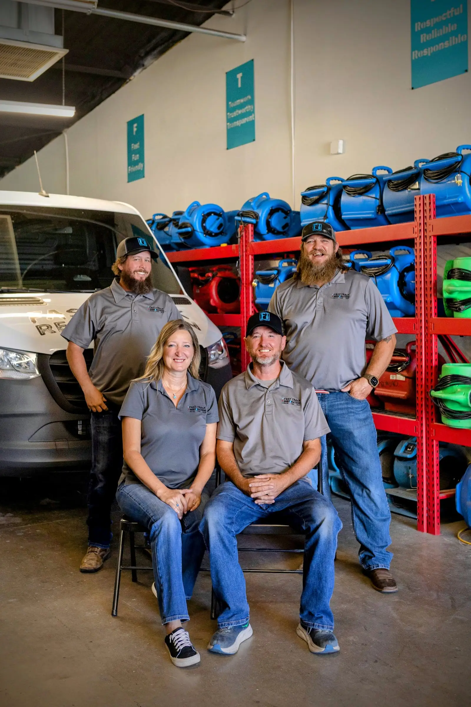 Fast Track Restoration's leadership team in the company's Mesa warehouse, in front of shelves of air movers