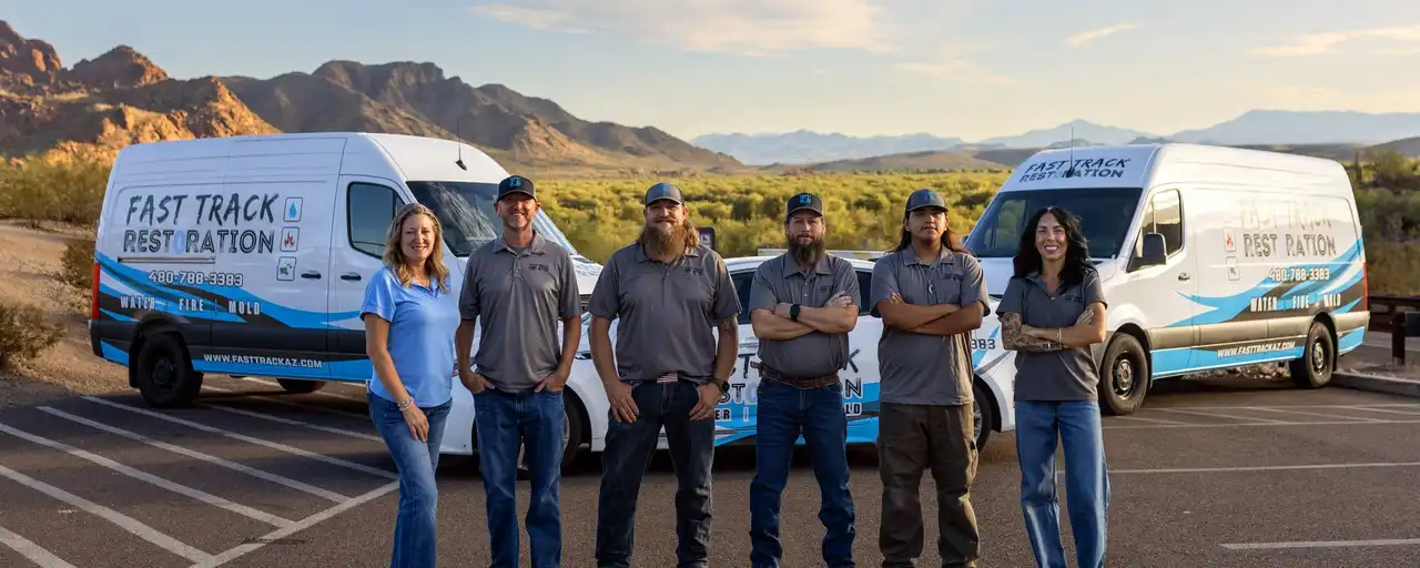 The Fast Track Restoration team standing in front of their company vans in the Arizona desert